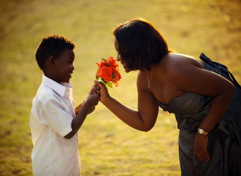 A young boy handing flowers to a woman Baraka roses, Ngorika, Nyandarua.
