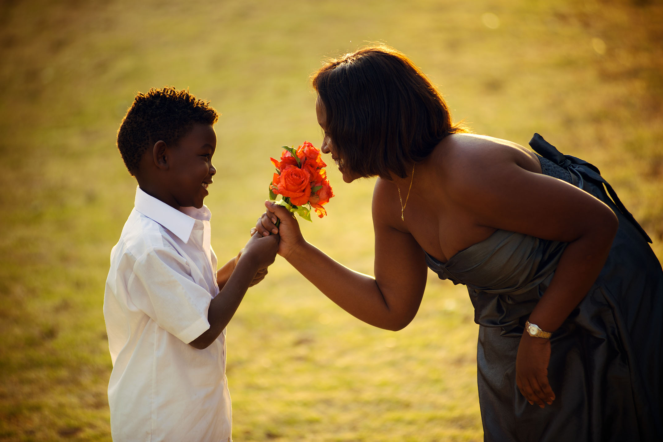 A young boy handing flowers to a woman Baraka roses, Ngorika, Nyandarua.