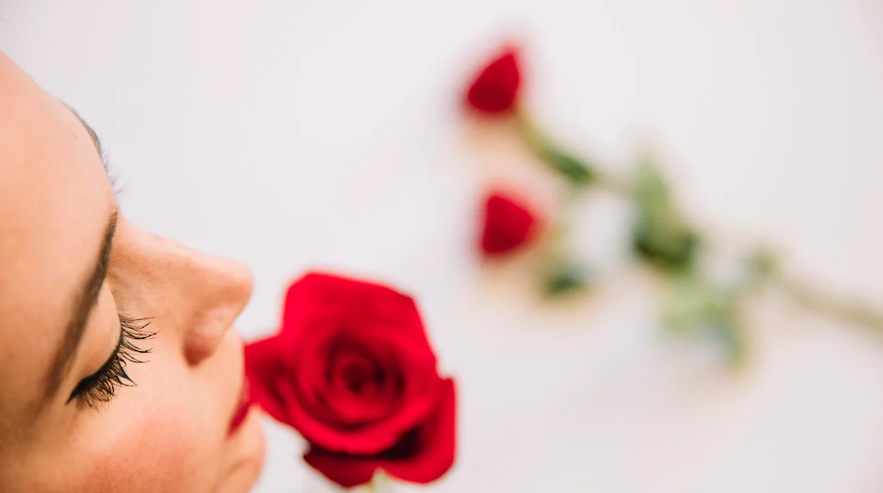 A woman smelling roses.