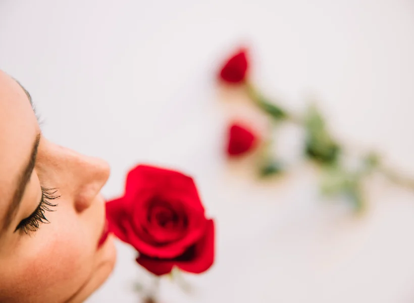 A woman smelling roses.